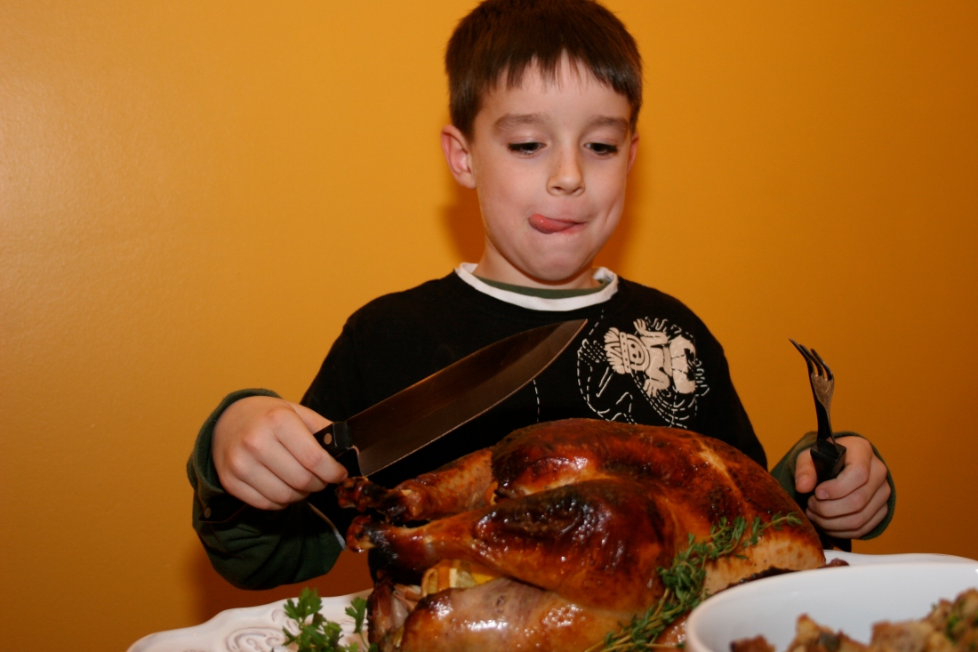 boy preparing to carve a turkey